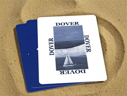 Two Dover branded playing cards on a sandy surface
