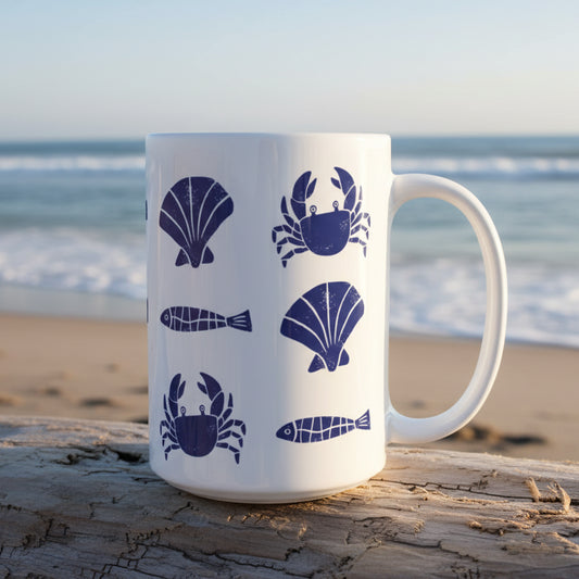 White mug with blue sea-themed illustrations on a white background