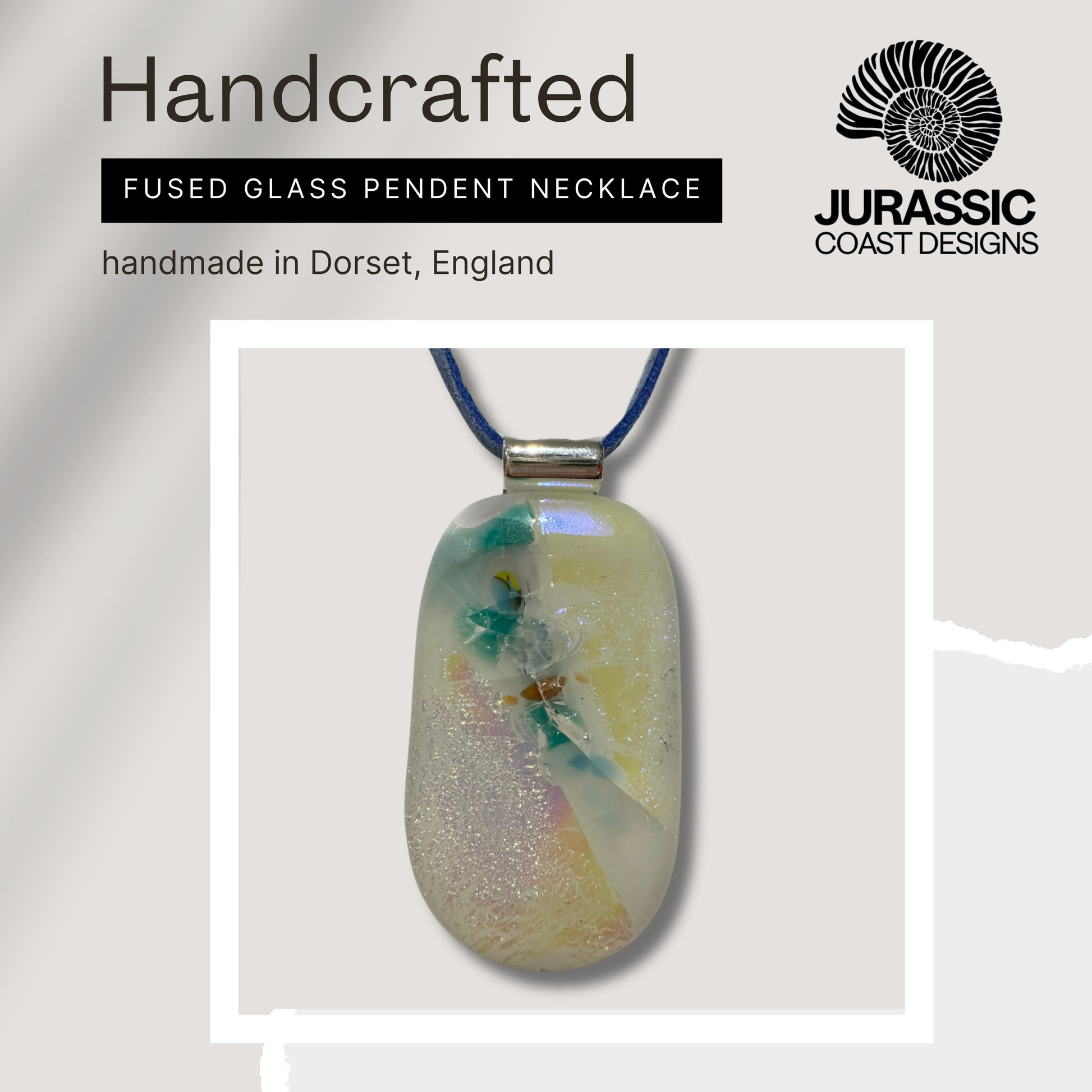 Handcrafted fused glass pendant necklace with 'Jurassic Coast Designs' branding on a light gray background.