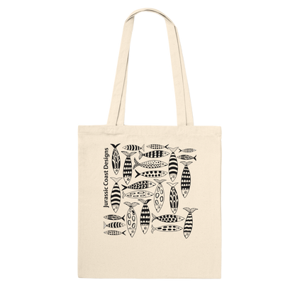 Beige tote bag with black fish pattern and 'Jurassic Coast Designs' text on a white background