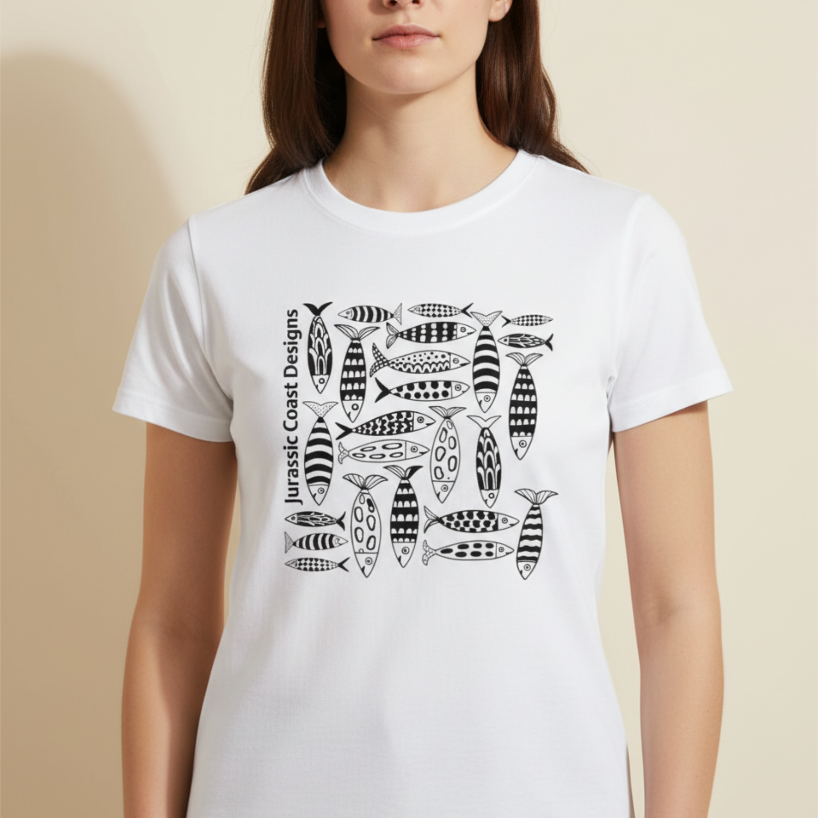 Person wearing a white t-shirt with black fish pattern design on a beige background