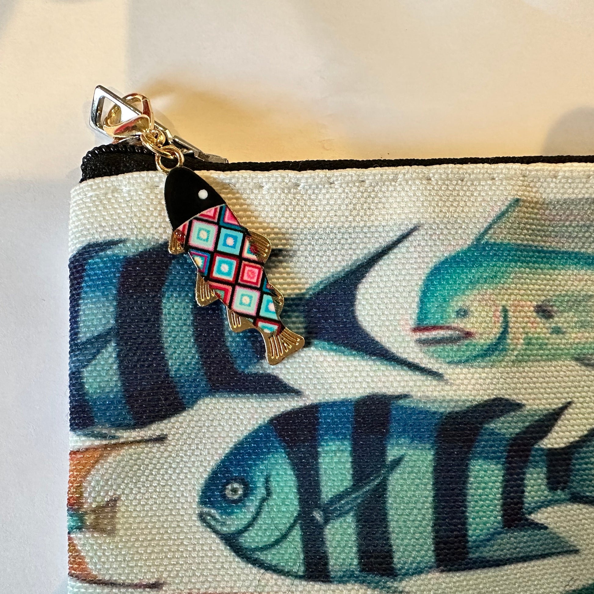 Pouch with fish design and colorful fish charm on a light background