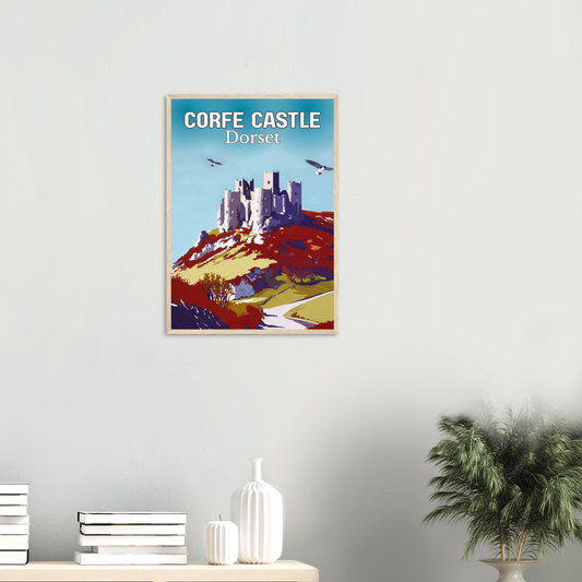 Framed poster of Corfe Castle, Dorset on a wall with decor items below.