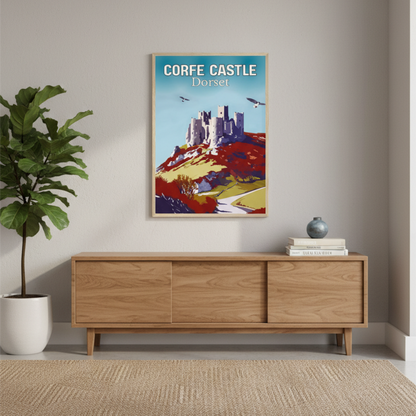 Poster of Corfe Castle on a wall above a wooden cabinet with a plant and books.