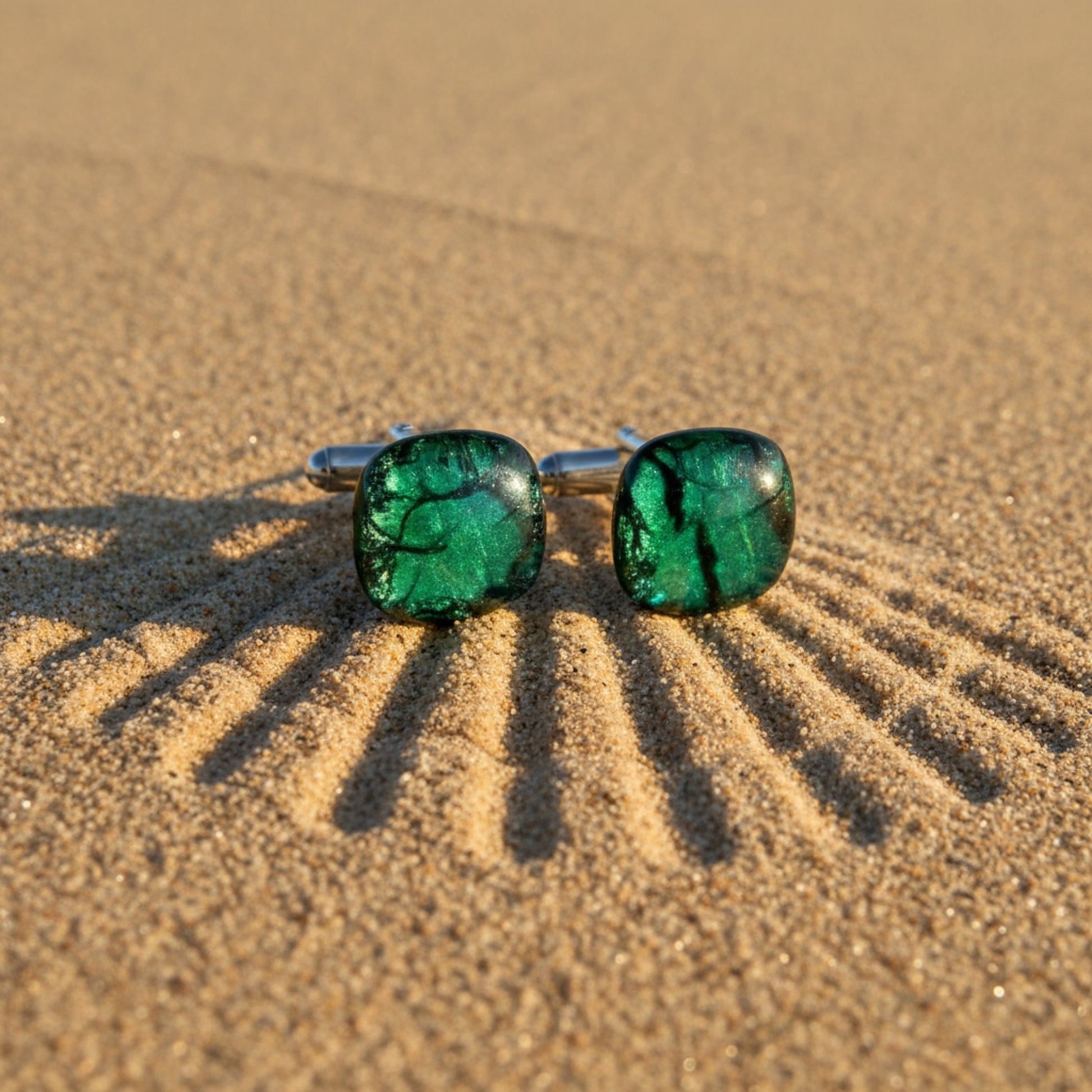 Green fused glass cufflinks on sand