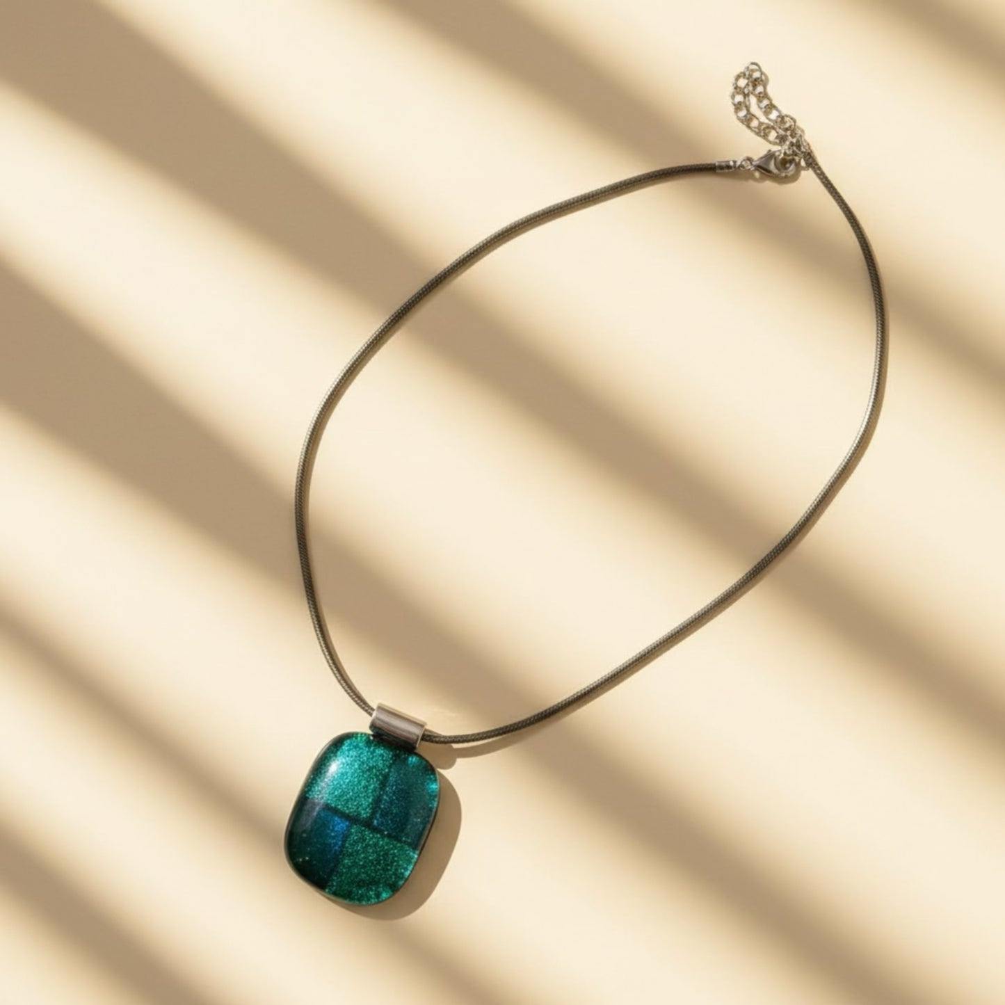 Necklace with a green pendant on a beige background