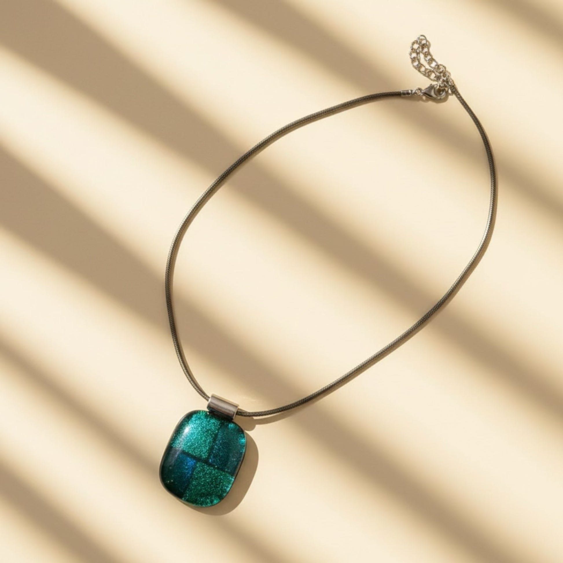 Necklace with a green pendant on a beige background