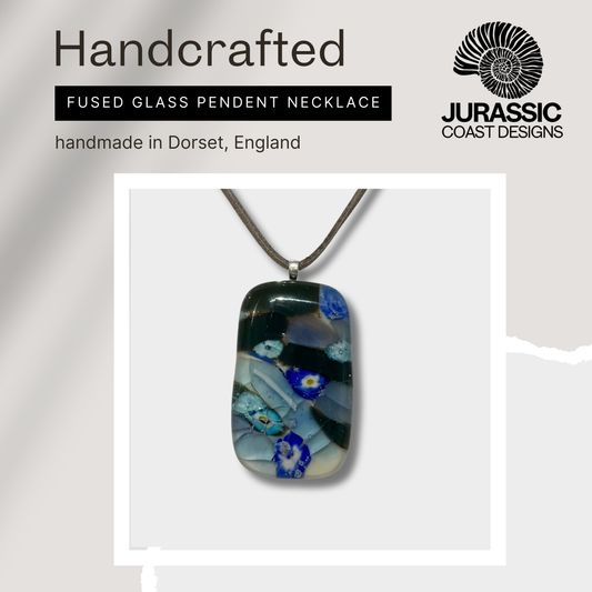 Handcrafted fused glass pendant necklace with floral design, branded 'Jurassic Coast Designs'.