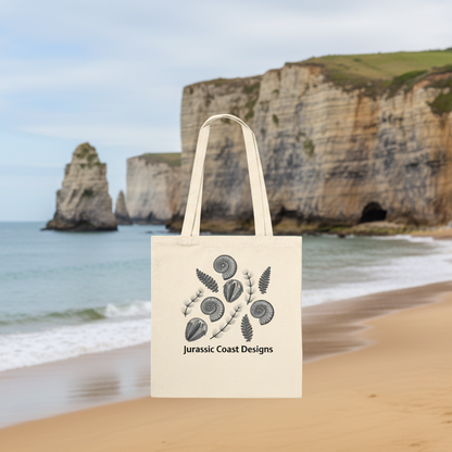 Beige tote bag with fossil and plant design and 'Jurassic Coast Designs' text on a white background