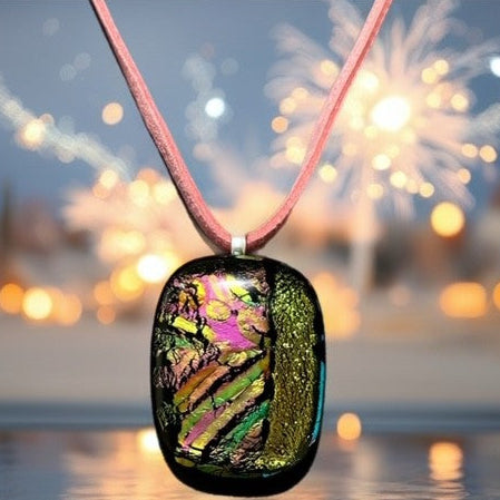 Colorful pendant on a pink cord with a blurred background of lights