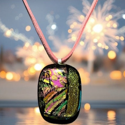 Colorful pendant on a pink cord with a blurred background of lights