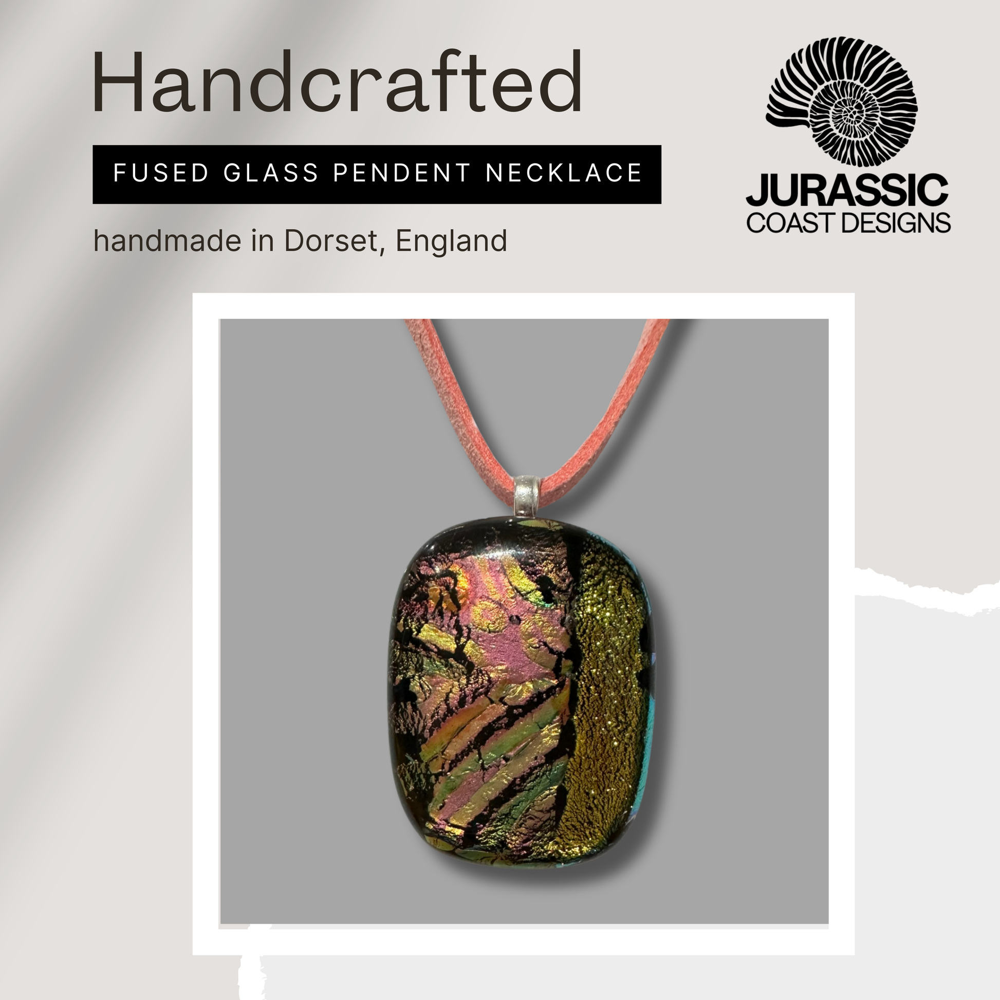 Handcrafted fused glass pendant necklace on a gray background with 'Jurassic Coast Designs' branding.