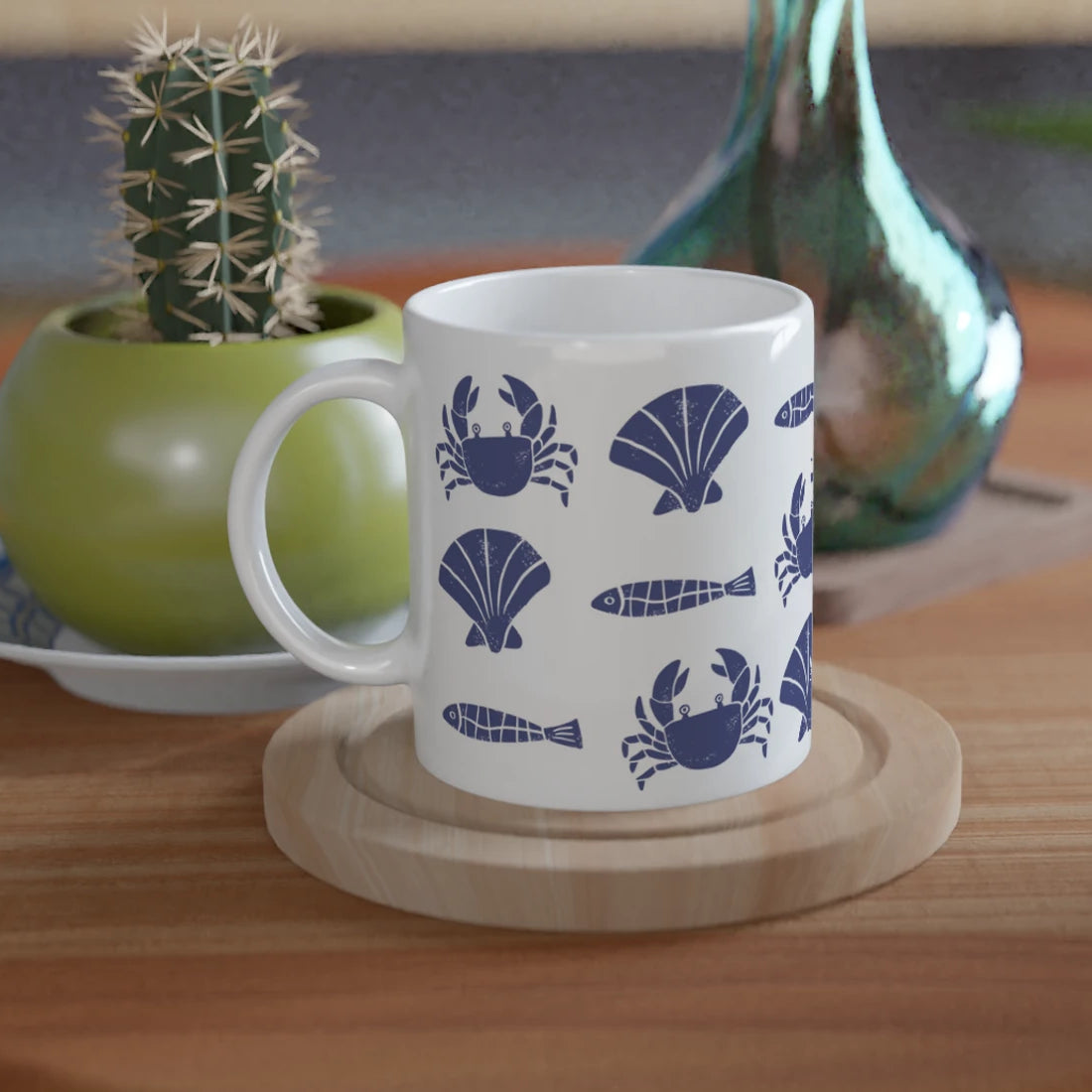 White mug with blue patterns on a wooden table with plants in the background