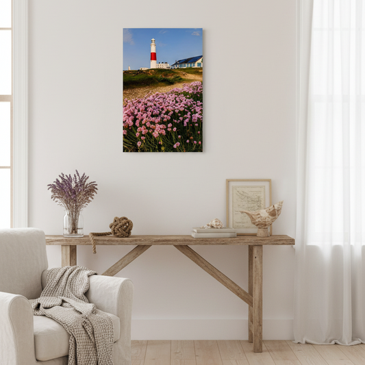 Portland Lighthouse with pink thift flowers in the foreground on a clear day