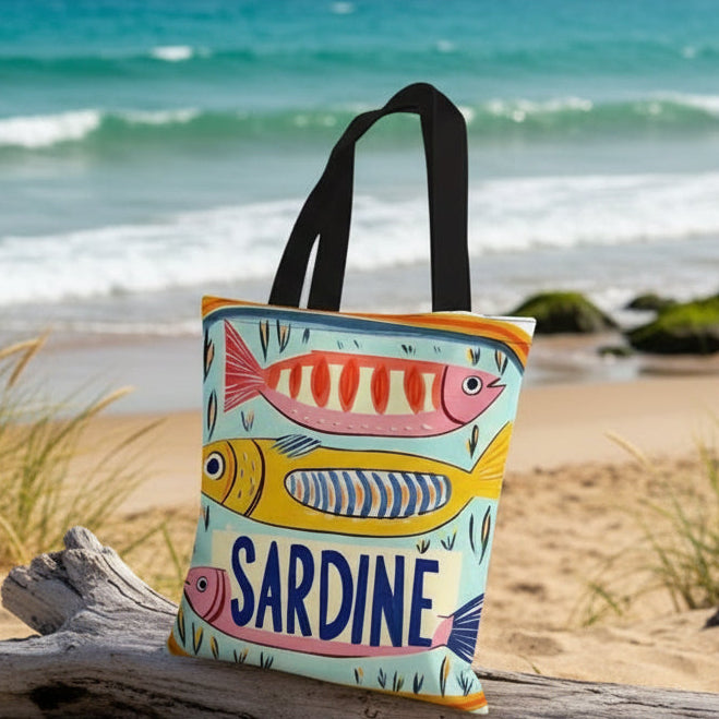 Tote bag with fish design and 'Sardine' text on a beige couch.