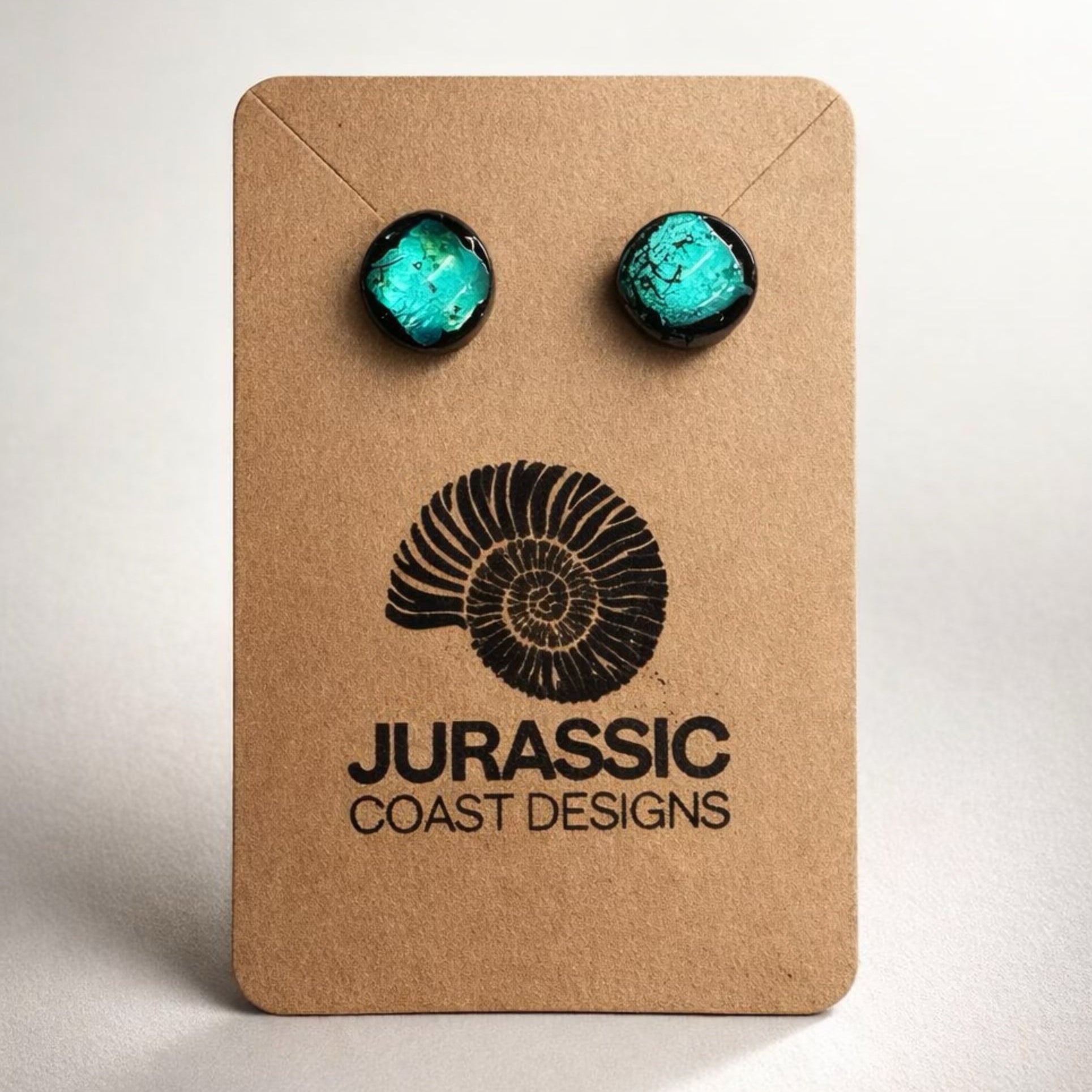 Turquoise earrings on a 'Jurassic Coast Designs' branded card against a white background