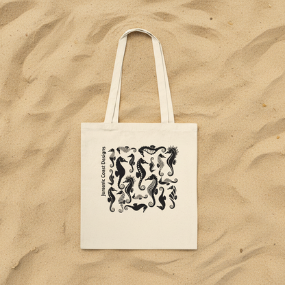 Beige tote bag with black seahorse design and 'Jurassic Coast Designs' text on a white background