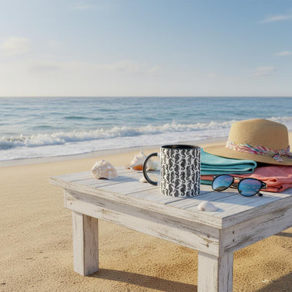 Beach scene with a wooden table, mug, sunglasses, and hat on a sandy beach with ocean view.