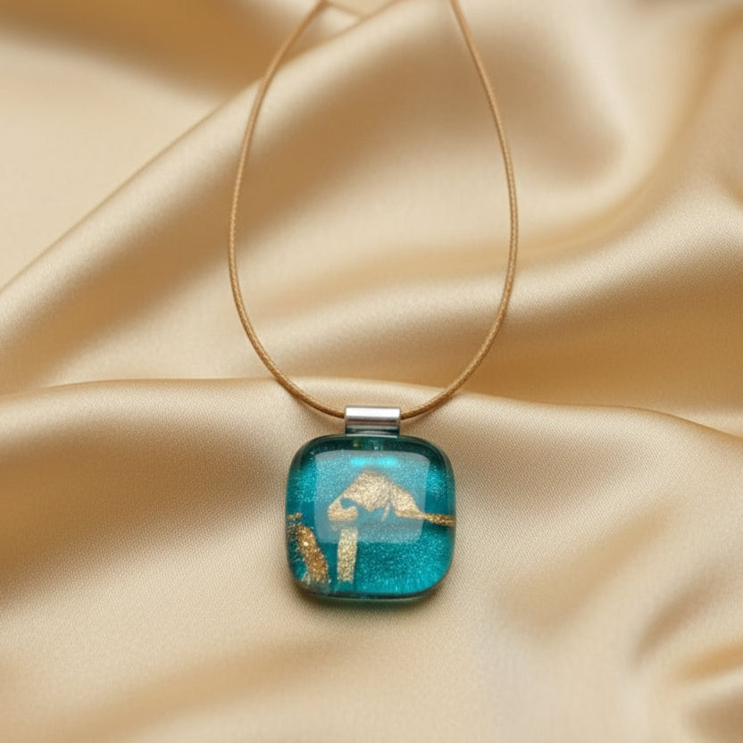 Necklace with a blue pendant featuring gold accents on a white background