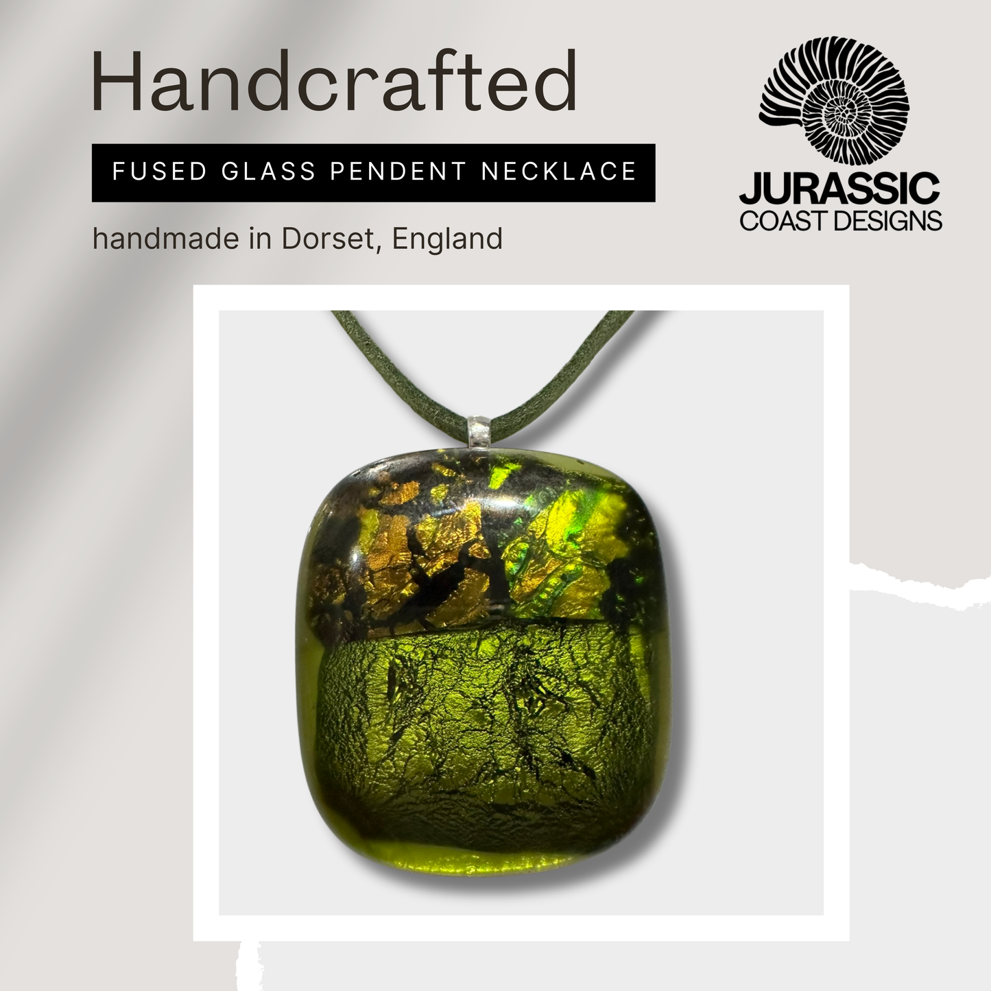 Handcrafted fused glass pendant necklace with 'Jurassic Coast Designs' branding on a light gray background.