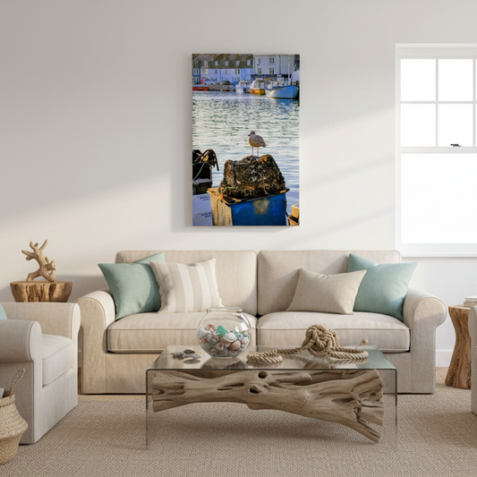Canvas print of a Weymouth harbour scene with a bird on a rock, houses, and boats.
