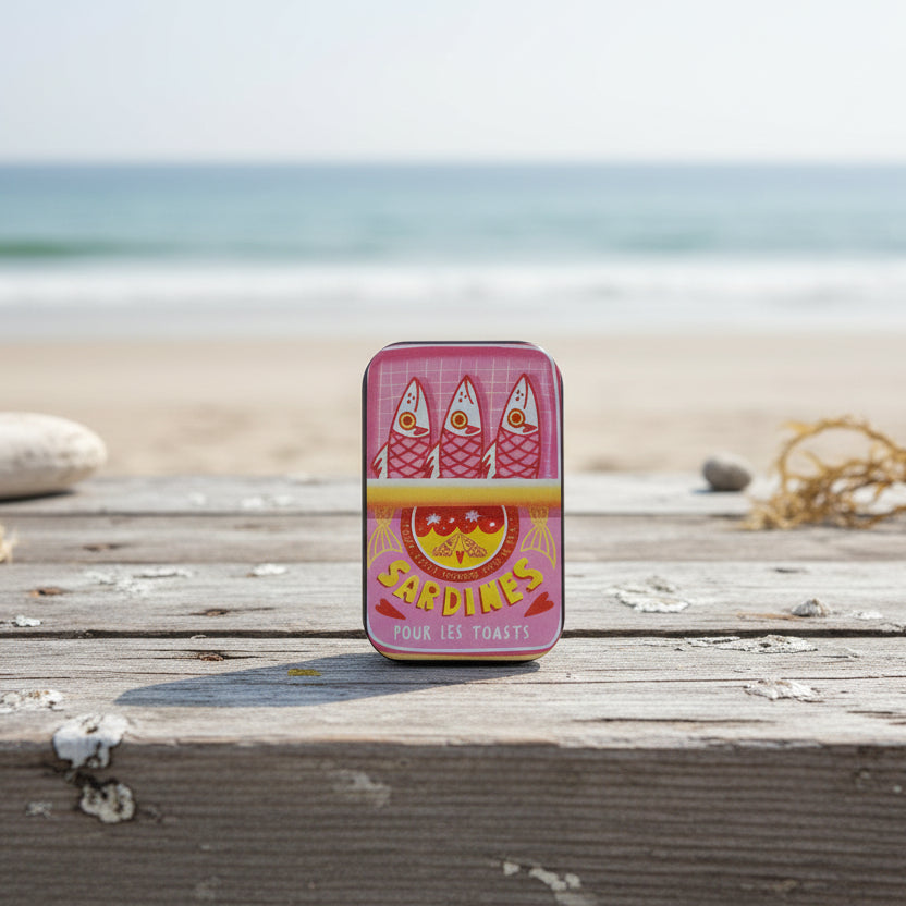 Sardine can-shaped container with vintage design on a white surface