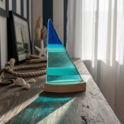 Glass sculpture with blue and green layers on a white surface
