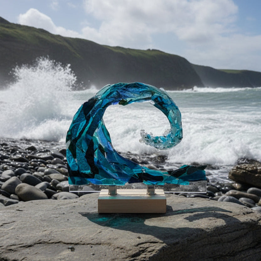 Blue glass sculpture on a white surface with a dark background
